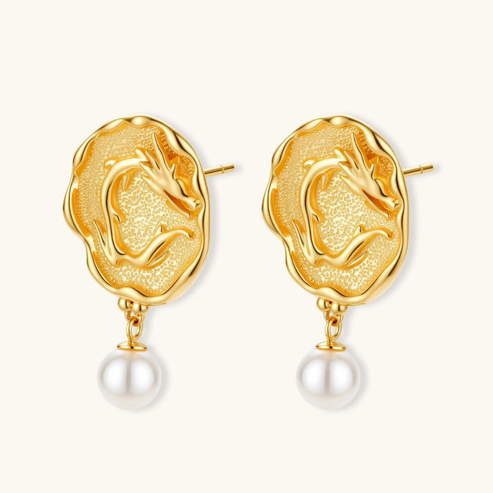 Ornate gold-plated dragon medallion earrings with white shell pearl drops on beige background, featuring detailed Chinese motifs.