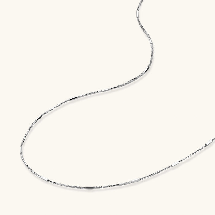 Delicate platinum-plated sterling silver necklace with alternating textured cubic links and smooth chain sections.