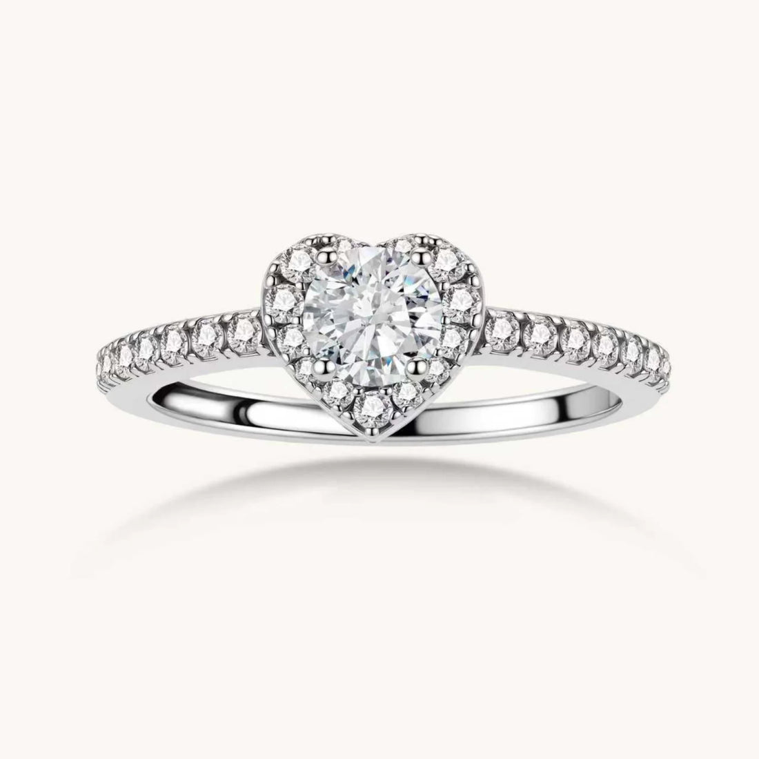 Heart-shaped halo ring with brilliant moissanite center stone surrounded by smaller crystals in sterling silver setting