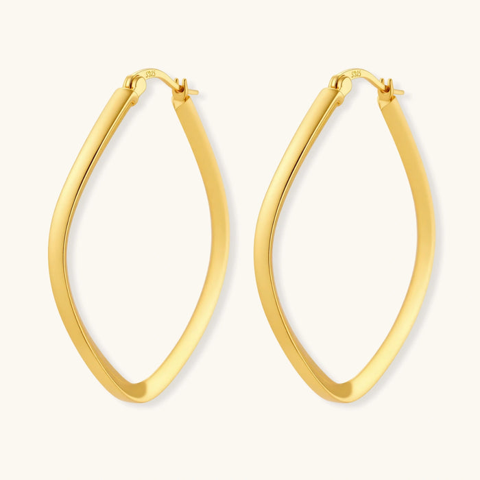 Set of geometric gold-plated sterling silver hoop earrings in oval and cushion shapes on cream background